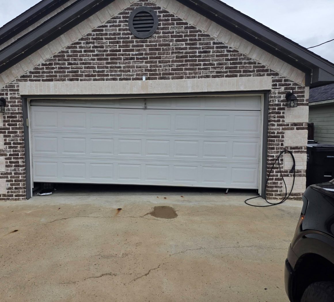 A garage door hanging off the track